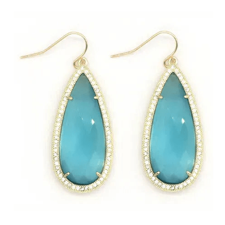 Close-up of turquoise teardrop earrings showing fishhook clasps and crystal details