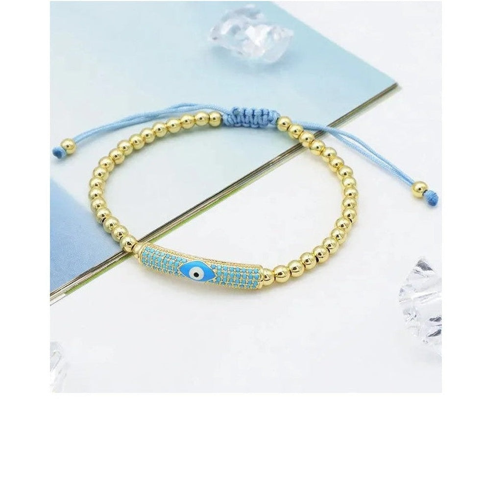 Gold adjustable bracelet with blue rhinestone bar charm and macrame cord