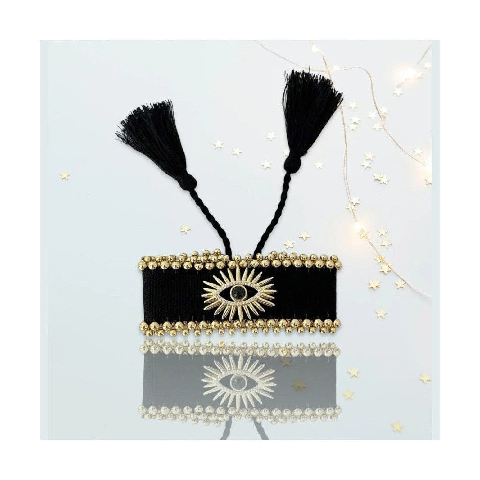Black woven Stella bracelet featuring gold bead rows and evil eye detail